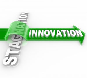 The word Innovation on an arrow jumping over the word Stagnation, symbolizing the forward motion of creative change over the status quo